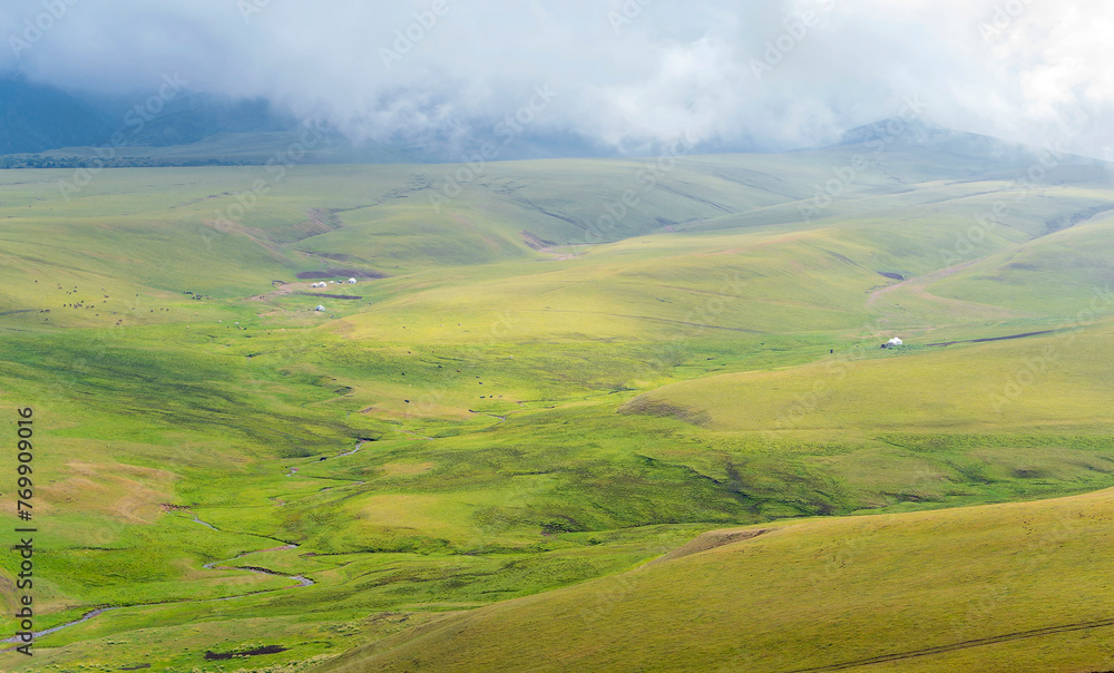 Summer landscape with green hills and cloudy sky. Plateau Assy, Kazakhstan
