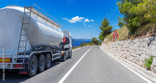 Fuel truck on a picturesque road. A white tank truck transports fuel.