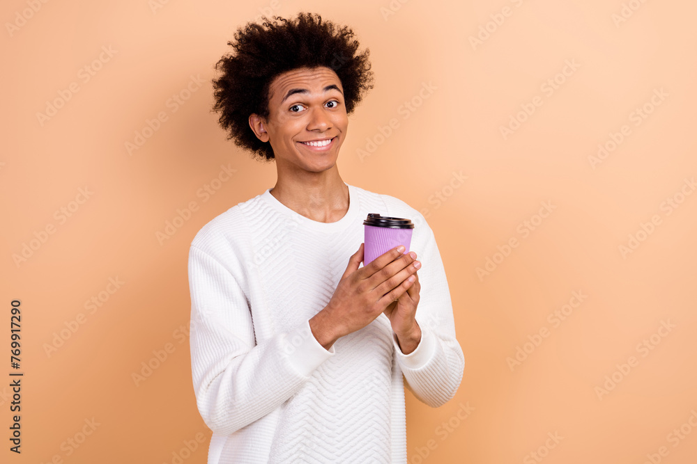 Photo of nice cheerful young man wear white clothes drinking tasty delicious tea isolated on beige color background