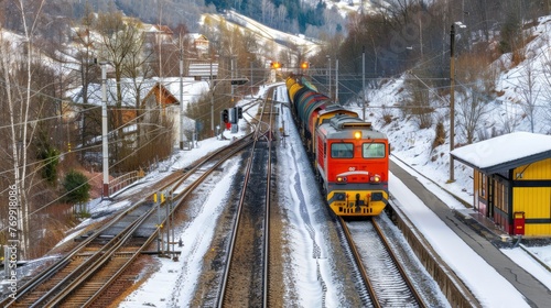 Travel train is traveling down the tracks in the snow. The train is red and yellow