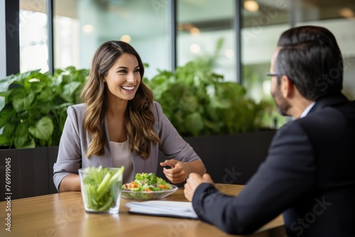 A dedicated young woman nutritionist educates a client one-on-one, emphasizing the significance of a well-balanced diet. She employs charts and food models to illustrate her guidance effectively. photo