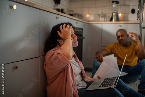 Man and woman discussing paperwork in kitchen photo