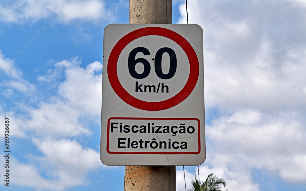 Traffic sign speed limit at 60 kilometers per hour and information in portuguese saying: electronic inspection