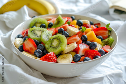 A bowl of fruit salad with strawberries, blueberries, kiwi, and bananas