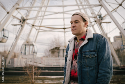 Wallpaper Mural Man Standing in Front of Ferris Wheel. A man stands in front of a large ferris wheel at an amusement park Torontodigital.ca