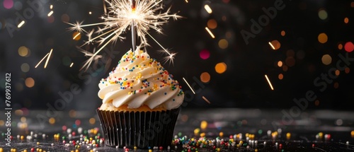 Happy birthday party celebration congratulation greeting card banner long - Cup cake with sparkling sparkler, isolated on dark black table background © Corri Seizinger