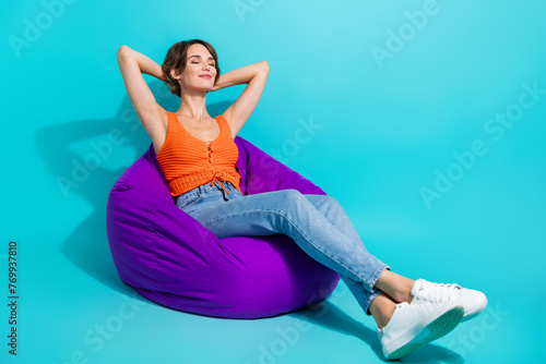 Schilderij op canvas Full length photo of good mood adorable woman dressed knit singlet chill on pouf