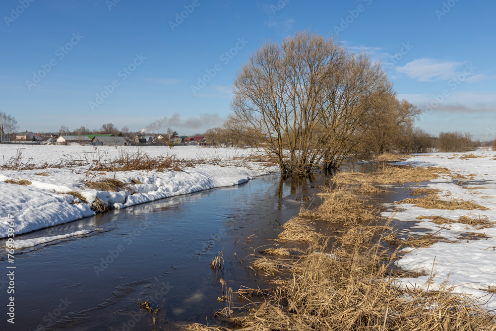 Early spring, melting snow, under the bright rays of the sun, thawed patches in the snow, colorful winter landscape Early spring, melting snow, under the bright rays of the sun, thawed patches in the snow, colorful winter landscape