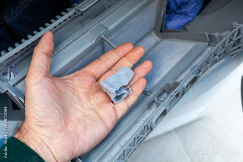 Hand removing lint from a clothes dryer filter, home maintenance