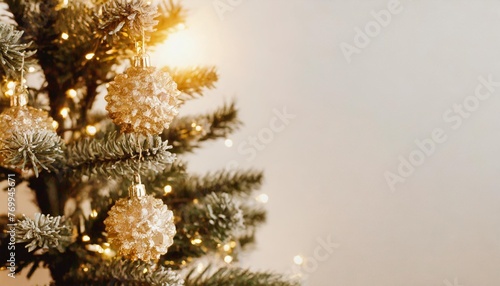 christmas tree with white background has a gold shiny ornament for blur background