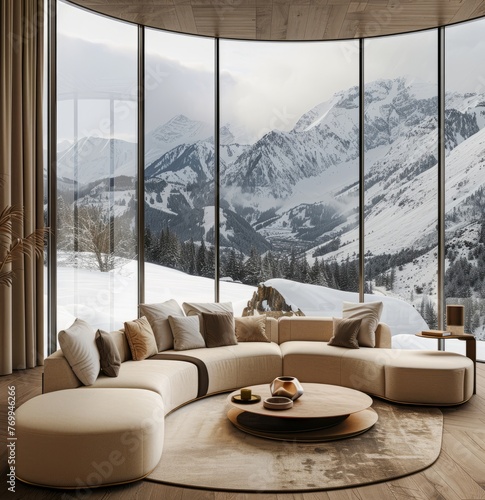 A living room with a beige sofa and coffee table, in a circular shape, with a warm color tone, featuring floor-to-ceiling windows overlooking the snow capped mountains outside