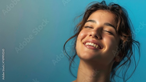 Portrait of the happy woman on blue background.