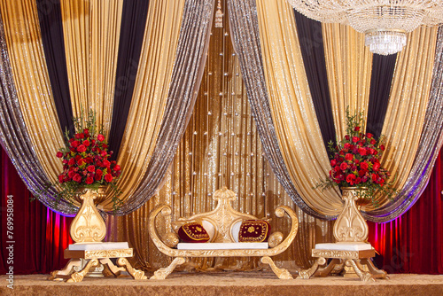 Indian wedding reception stage with rose arrangements