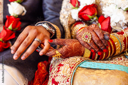 Muslim bride and groom holding hands during ceremony