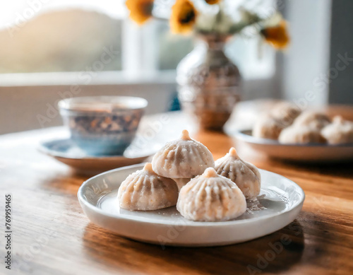 Delicious maamoul cookies on a white embossed plate, blurred teacup and bottle background enhance focus on dessert