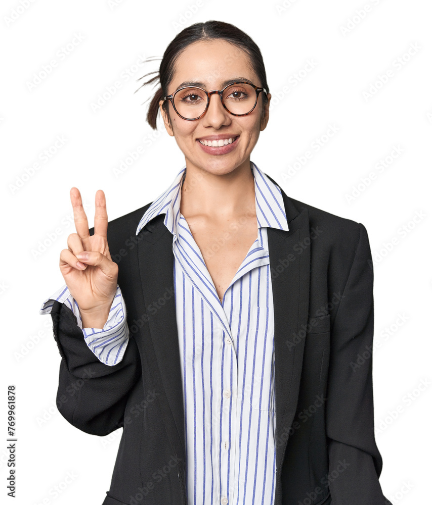 Confident young Caucasian businesswoman on studio background showing victory sign and smiling broadly.