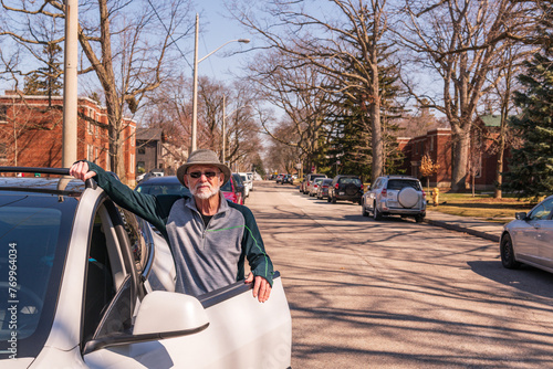 Canvas Print green economy: a senior citizen ( man with hat sunglasses and beard) stands besi