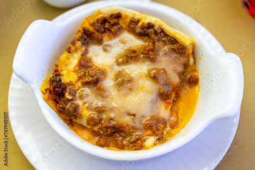 Traditional first course for lunch or dinner in Italy, lasagne Bolognese with beef meat and bechamel sauce served in Italian restaurant, Milan, Italy
