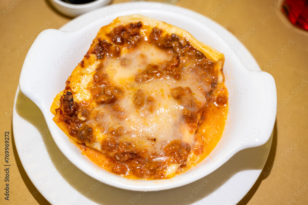 Traditional first course for lunch or dinner in Italy, lasagne Bolognese with beef meat and bechamel sauce served in Italian restaurant, Milan, Italy Traditional first course for lunch or dinner in Italy, lasagne Bolognese with beef meat and bechamel sauce served in Italian restaurant, Milan, Italy