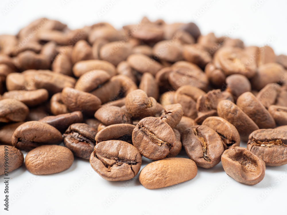 close-up of roasted arabica coffee beans lie on a white background. close-up of roasted arabica coffee beans lie on a white background.
