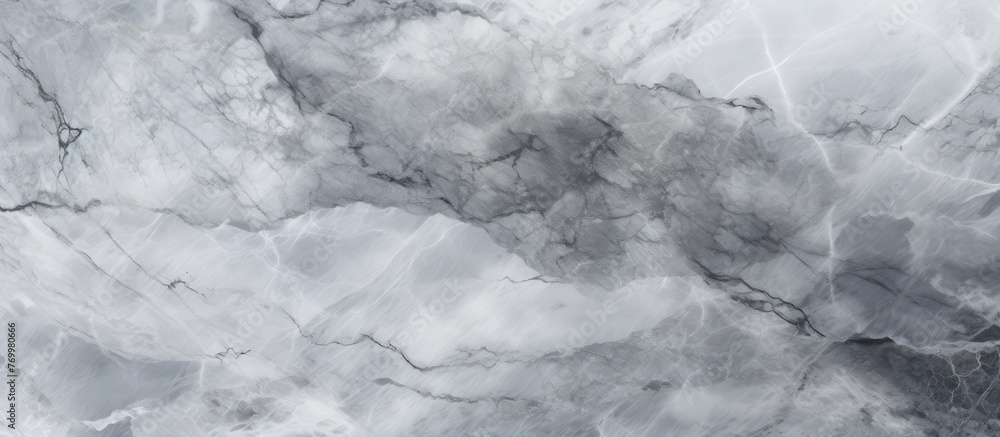 Naklejka premium A close up of a gray marble texture with a cloudy sky in the background, capturing the contrast between the smooth rock and the fluffy cumulus clouds in freezing weather
