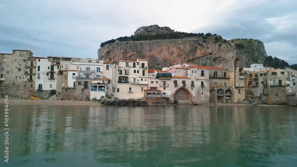 Aerial view of Cefalu, Sicily. Cinematic drone shot of famous travel destination of Italy. Slow drone shot travelling forward at low altitude and gaining altitude above the waves Aerial view of Cefalu, Sicily. Cinematic drone shot of famous travel destination of Italy. Slow drone shot travelling forward at low altitude and gaining altitude above the waves