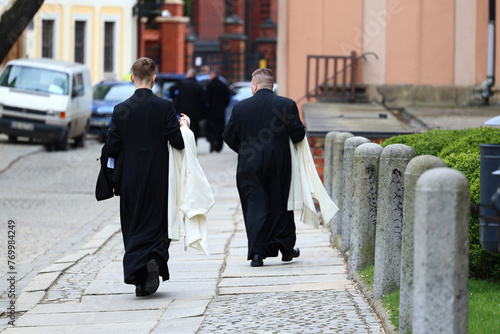 Ksiądz katolicki w czarnej sutannie idzie na mszę świętą photo