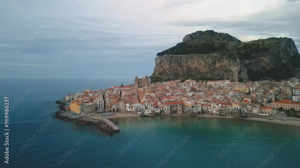 Aerial view of Cefalu, Sicily. Establishing cinematic drone shot of famous travel destination of Italy, view of Cefalu Cathedral. Slow drone shot travelling toward the historic town from the sea. Aerial view of Cefalu, Sicily. Establishing cinematic drone shot of famous travel destination of Italy, view of Cefalu Cathedral. Slow drone shot travelling toward the historic town from the sea.