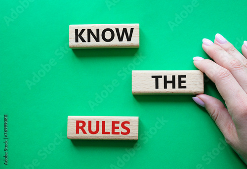 Know the rules symbol. Wooden blocks with words Know the rules. Beautiful green background. Businessman hand. Business and Know the rules concept. Copy space.