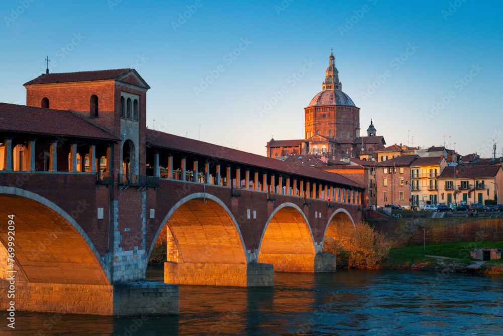 Panorama of covered bridge and Pavia cathedral at sunset