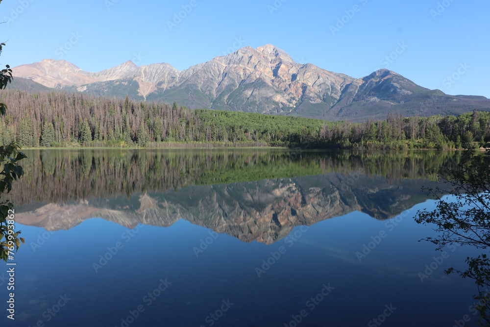 Pyramid Mountain reflected in the early morning, still, glass like waters of the stunning Patricia Lake near Jasper in the Canada rockies
