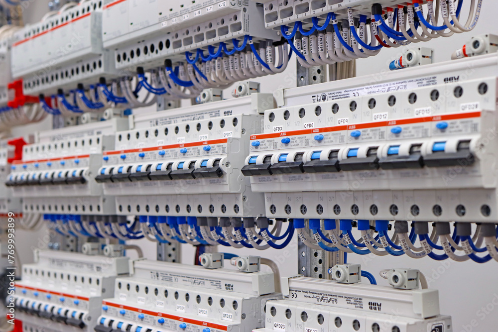 Electric circuit breakers for the protection of electrical loads are installed in an electrical distribution cabinet.