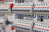 Electric circuit breakers for the protection of electrical loads are installed in an electrical distribution cabinet.