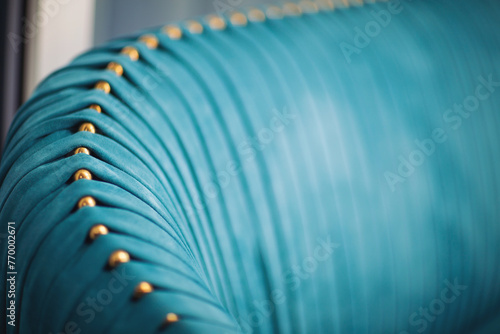 Luxury of blue fabric. beautiful blue velour frabic sofa decorate with golden buttons. Blue teal velvet capitone textile background, retro style checkered soft tufted turquoise fabric furniture. photo