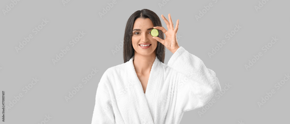 Young woman with cucumber slice on light background Young woman with cucumber slice on light background