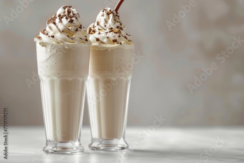 Two smooth milkshakes on white tabletop