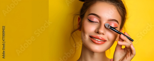 Vibrant Makeup Routine: Girl Applies Cosmetics on Vivid Backdrop photo