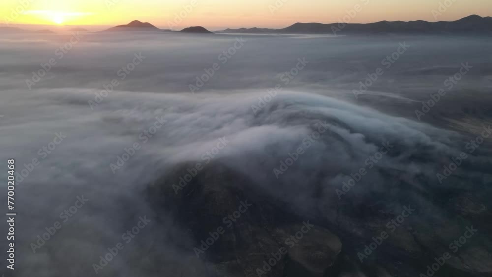 Ethereal clouds flow over the serene hills of Fuerteventura as the day gently breaks Ethereal clouds flow over the serene hills of Fuerteventura as the day gently breaks