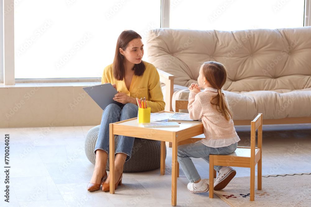Female psychologist working with little girl at table in office Female psychologist working with little girl at table in office