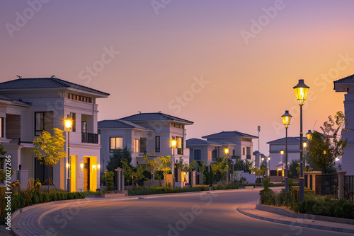 A tranquil twilight over a luxury housing estate with modern villas softly illuminated by street lamps. / © M Arif