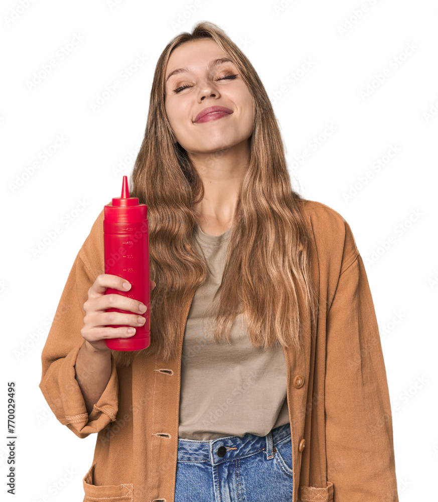 Blonde woman holding ketchup bottle in studio setting dreaming of achieving goals and purposes Blonde woman holding ketchup bottle in studio setting dreaming of achieving goals and purposes