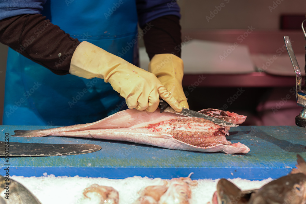 fishmonger cleaning the fish with knives