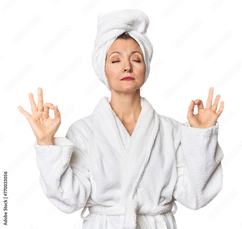 Caucasian woman in bathrobe and towel relaxes after hard working day, she is performing yoga. Caucasian woman in bathrobe and towel relaxes after hard working day, she is performing yoga.