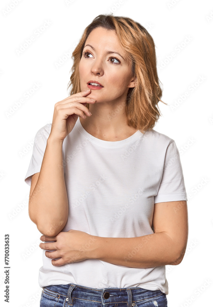 Blonde middle-aged Caucasian woman in studio looking sideways with doubtful and skeptical expression. Blonde middle-aged Caucasian woman in studio looking sideways with doubtful and skeptical expression.