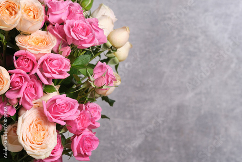 Beautiful bouquet of fresh roses on grey background.