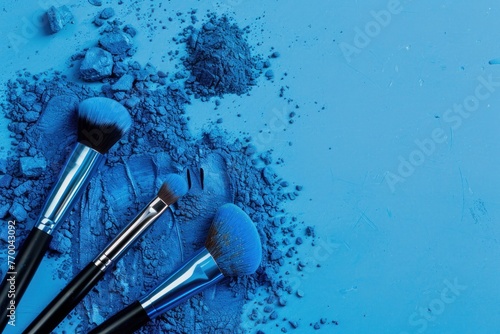 Blue powder with makeup brushes on a blue background