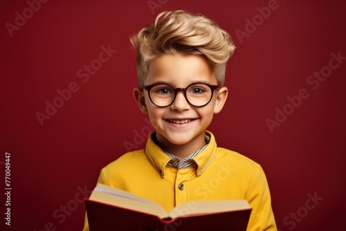 Portrait of an adorable boy with a book on a bright background