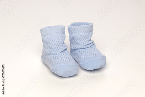 baby socks, for newborns, the first shoes with delicate feet on a light background