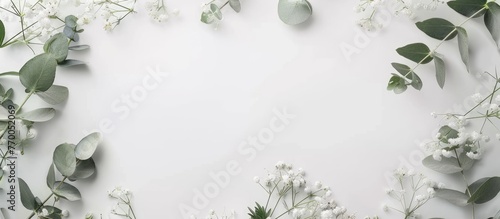 Wedding invitation or greeting card template with eucalyptus and gypsophila flowers on a paper background in a flat lay presentation.