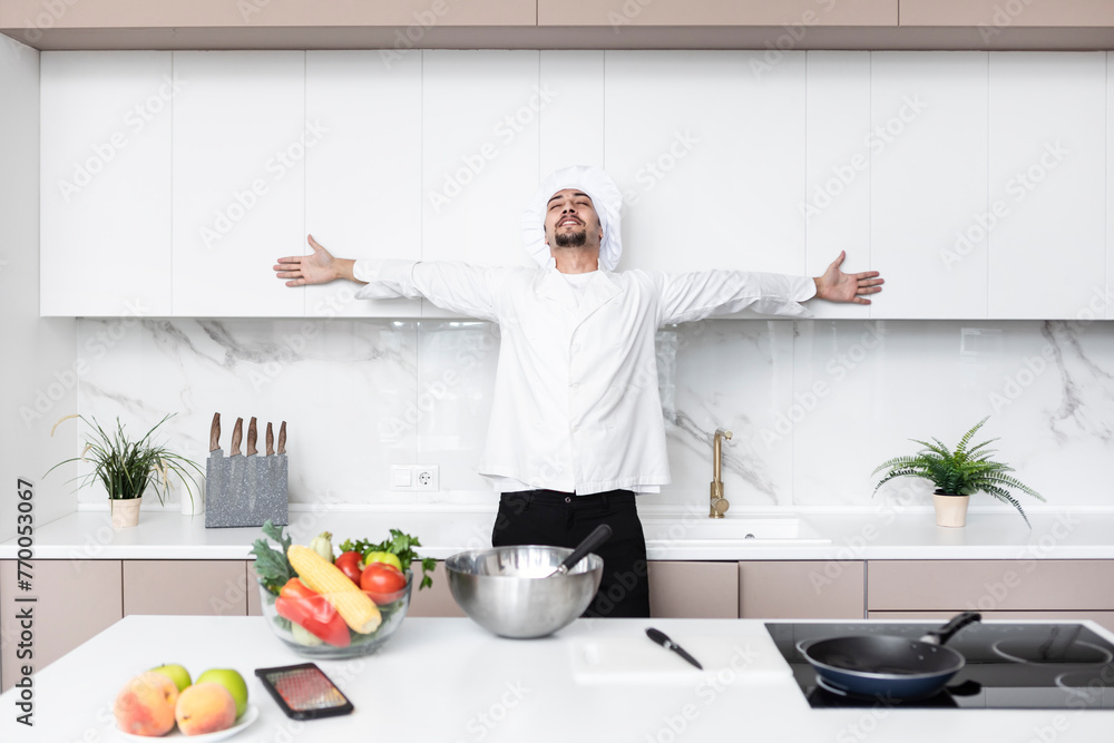Young handsome male chef in cooking in the kitchen Young handsome male chef in cooking in the kitchen